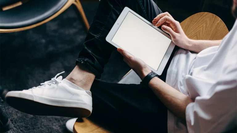 Stock photo - person sitting and holding a tablet banner