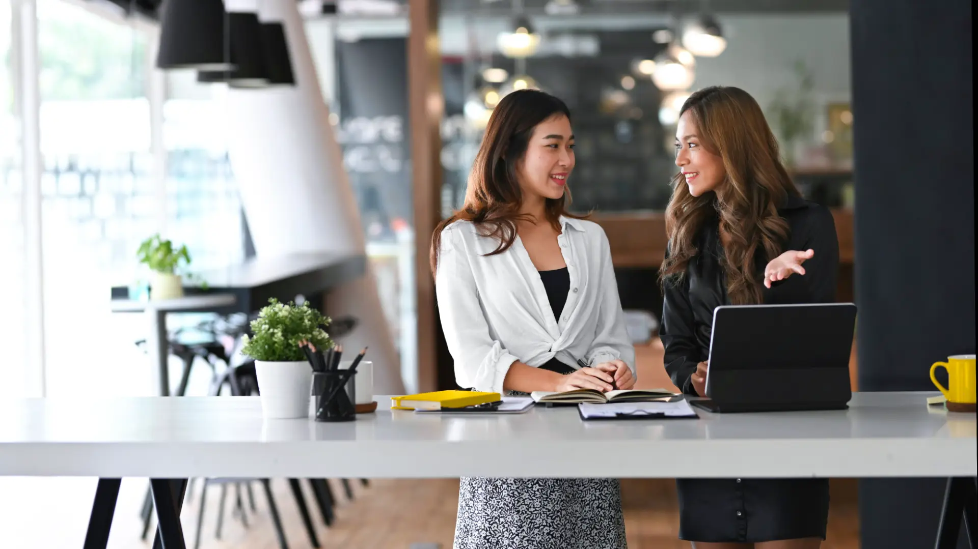 Two women discussing around a standing table